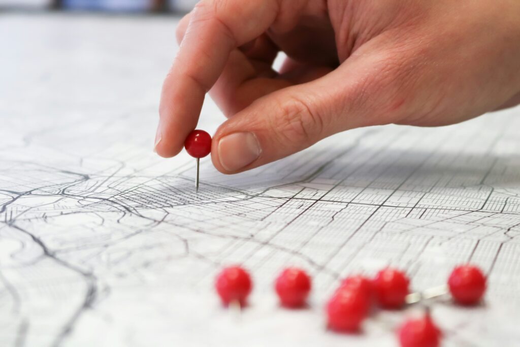 Main plaçant une épingle sur une carte pour localiser un commerce local